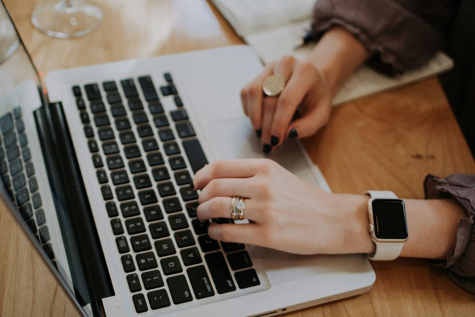 A woman typing on a laptop keyboard.